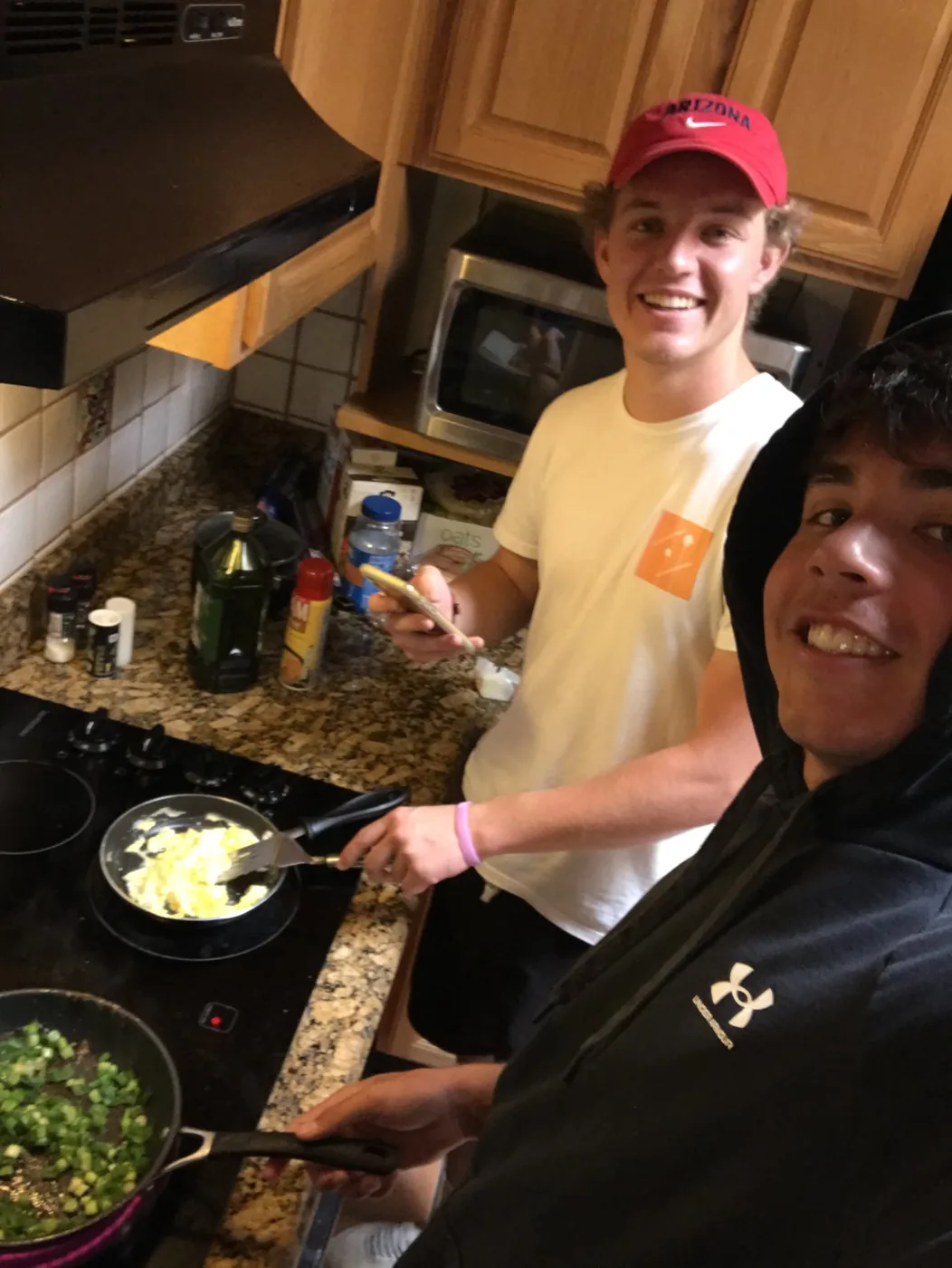Noah and Blake cooking eggs in the kitchen