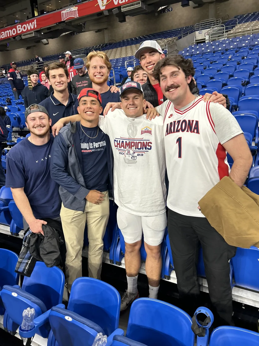 Tyler in his Alamo Bowl Champions shirt with friends after the win