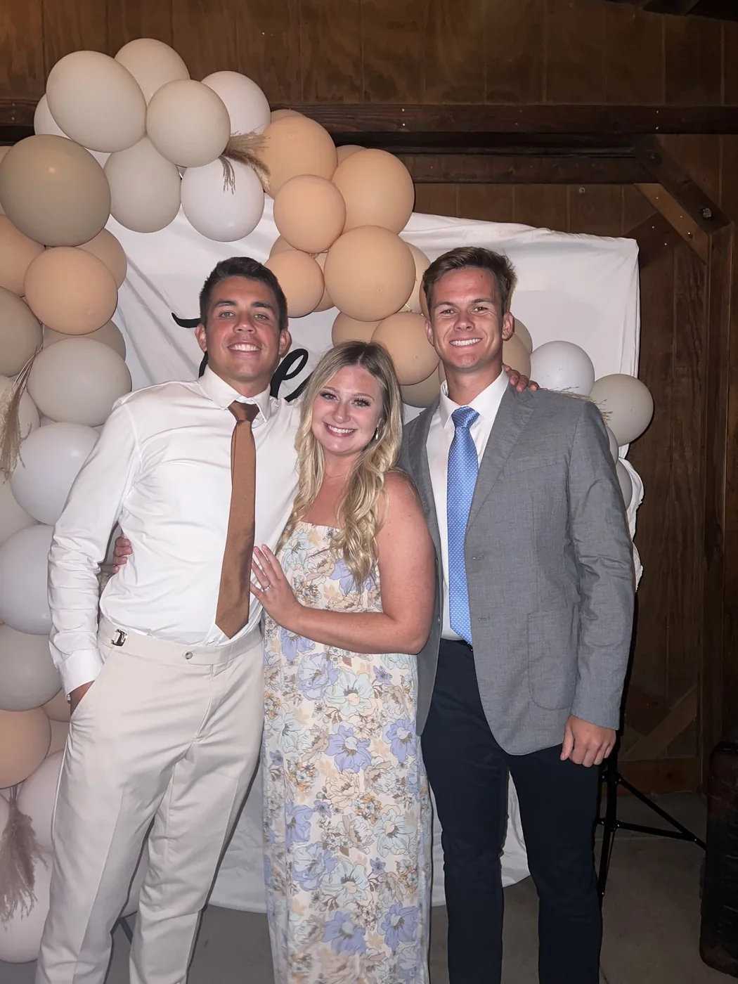 Tyler, Hannah, and Blake at an event with a balloon arch